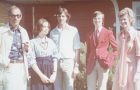 Five individuals dressed in period clothing from the 1970s.