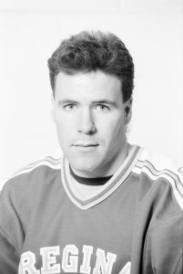 Black and white archival image of individual in hockey jersey