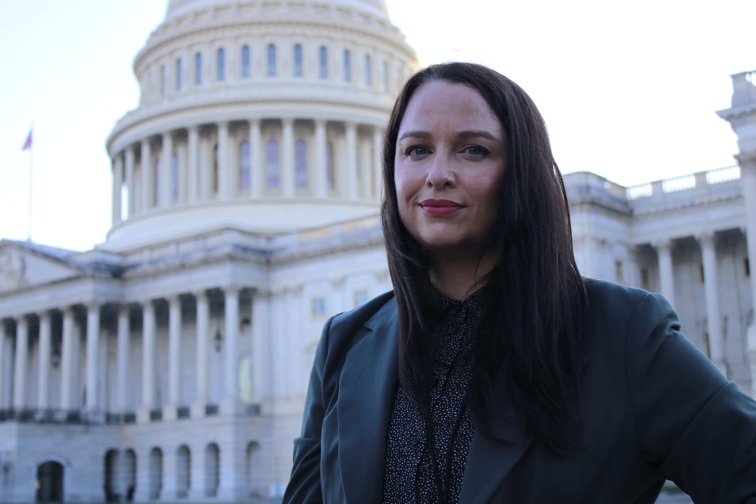 Smiling individual in front of the Capitol Building in Washington, DC.