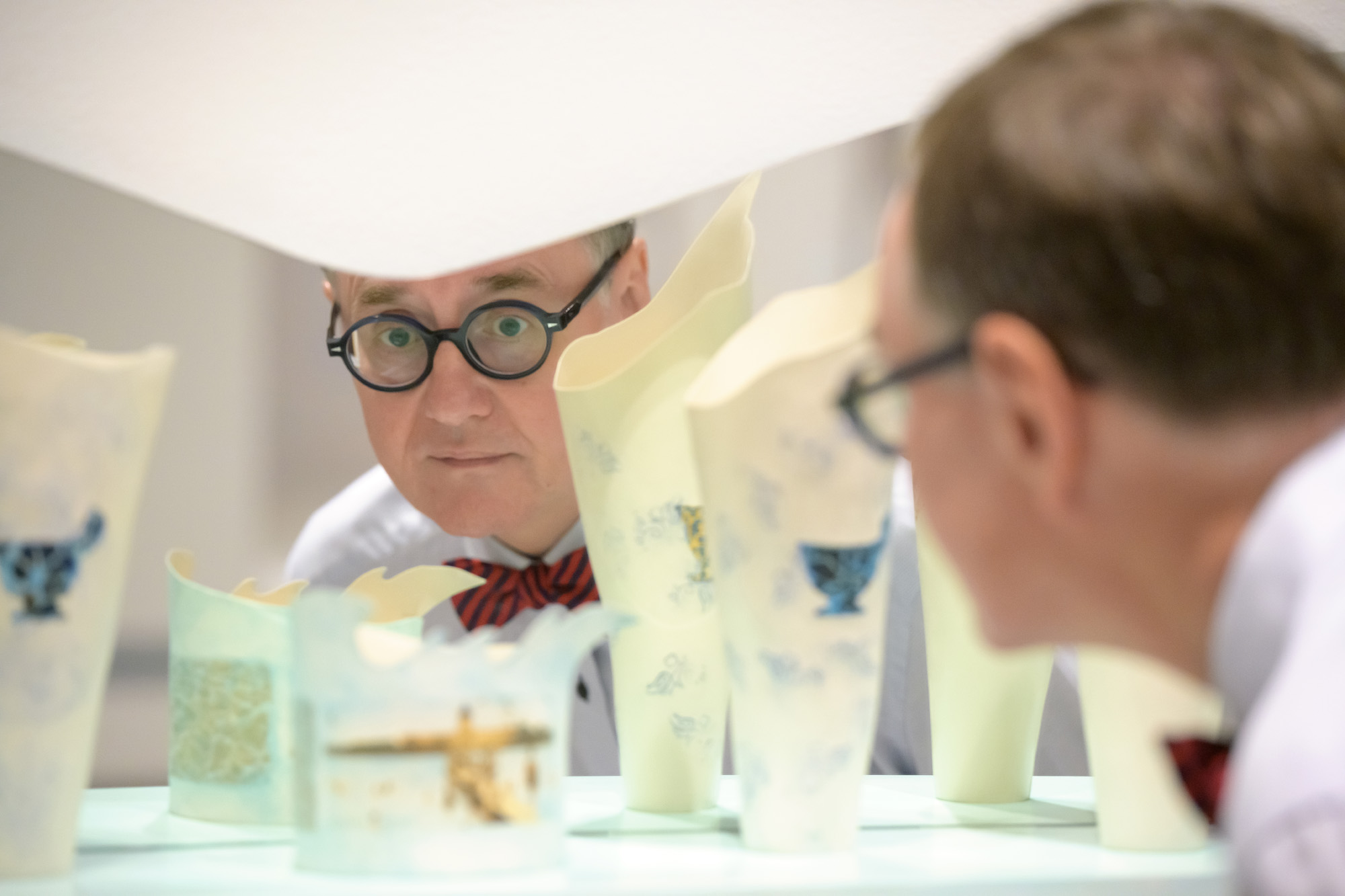 Individual looks at ceramic artworks on display.